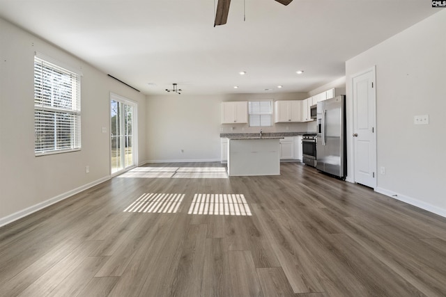 unfurnished living room featuring ceiling fan and light wood-type flooring