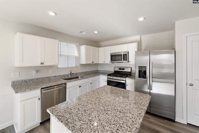 kitchen with a center island, stainless steel appliances, white cabinetry, and sink