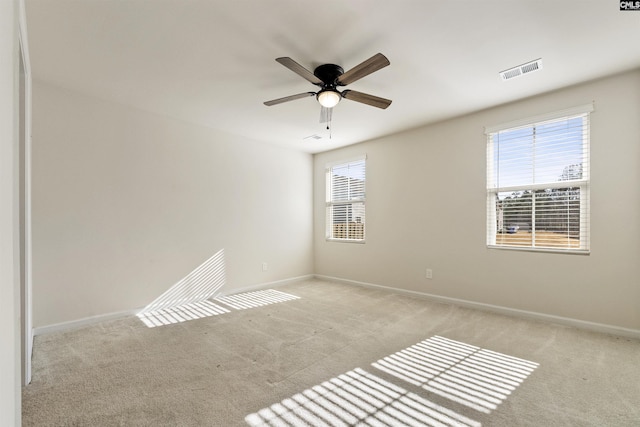 carpeted empty room with ceiling fan and a healthy amount of sunlight