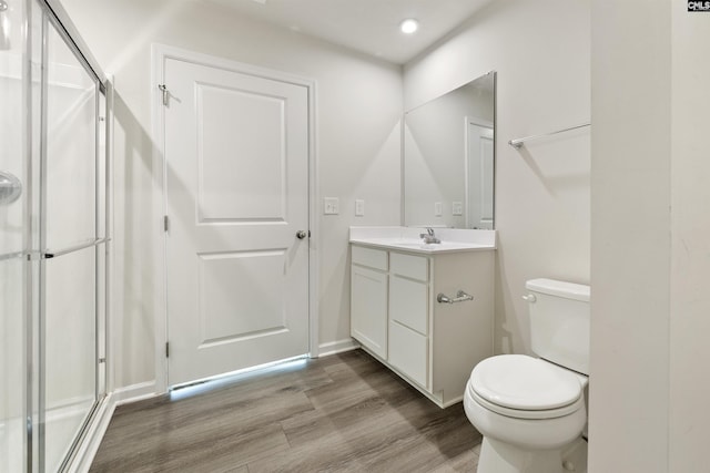 bathroom with vanity, hardwood / wood-style flooring, toilet, and walk in shower