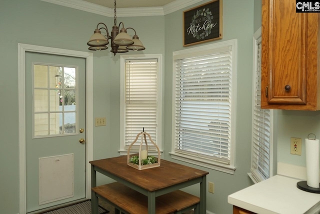 dining space with ornamental molding and a chandelier