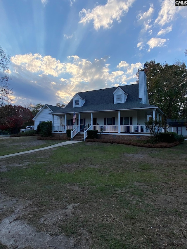 farmhouse-style home with a front yard and covered porch