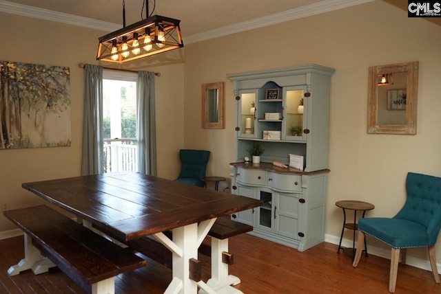 dining area with crown molding and hardwood / wood-style flooring