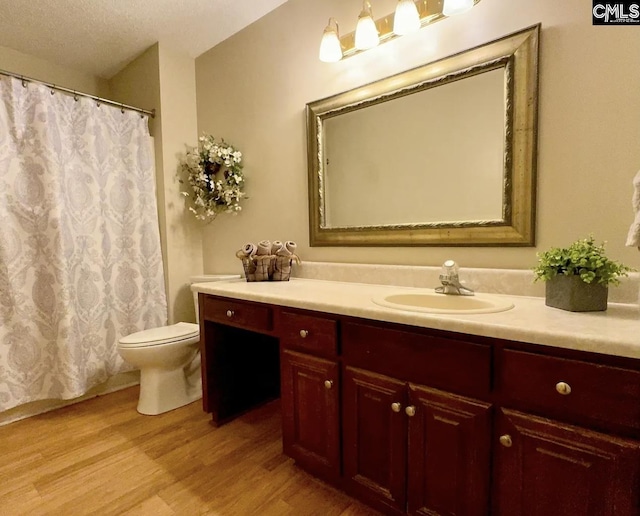 bathroom with hardwood / wood-style floors, vanity, and toilet