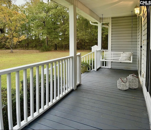 wooden deck featuring a porch and a yard