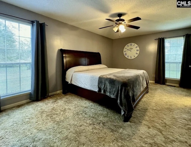 carpeted bedroom featuring a textured ceiling and ceiling fan