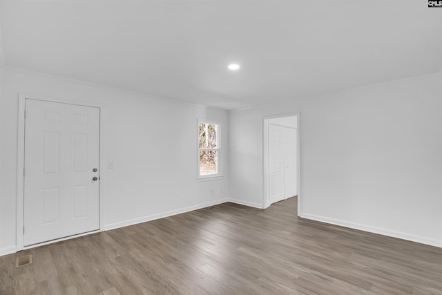 unfurnished room featuring hardwood / wood-style flooring and crown molding