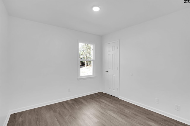 unfurnished room with dark hardwood / wood-style flooring