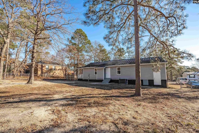 rear view of property with a yard and central AC