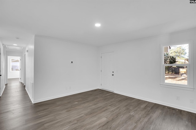 empty room with dark wood-type flooring and crown molding