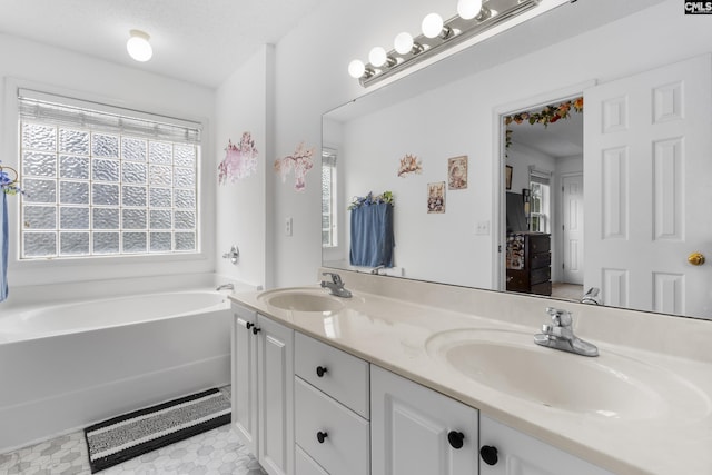 bathroom with vanity, tile patterned flooring, a textured ceiling, and a bathing tub