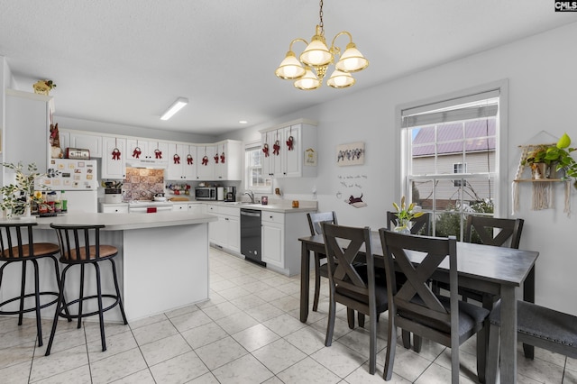 kitchen with white refrigerator, sink, white cabinetry, dishwasher, and a chandelier