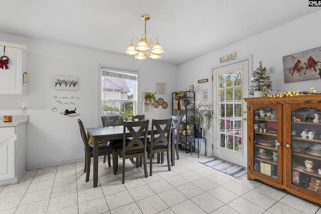 tiled dining room with a textured ceiling and a chandelier