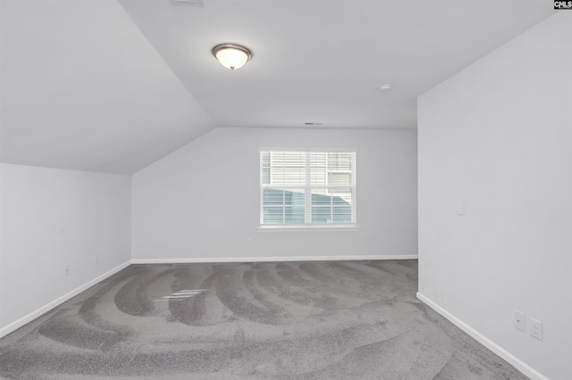 additional living space featuring carpet floors and vaulted ceiling