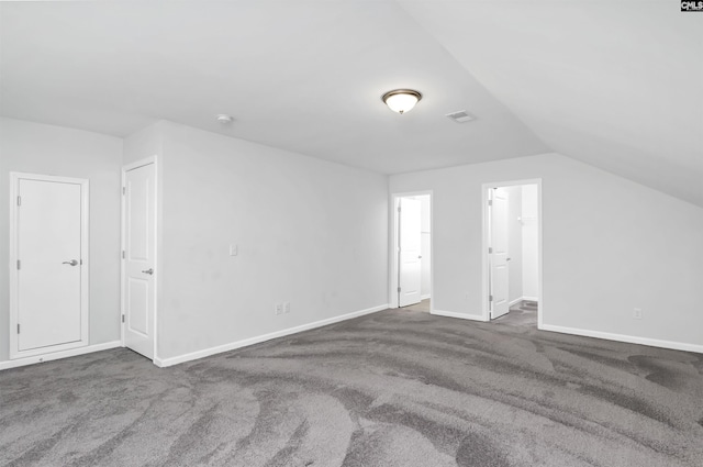 additional living space featuring vaulted ceiling and dark carpet