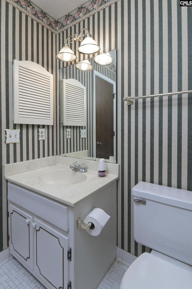 bathroom featuring tile patterned flooring, vanity, and toilet