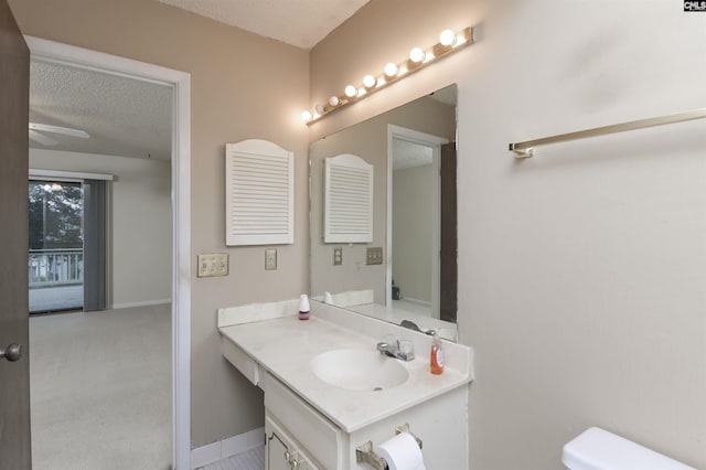 bathroom with toilet, vanity, and a textured ceiling