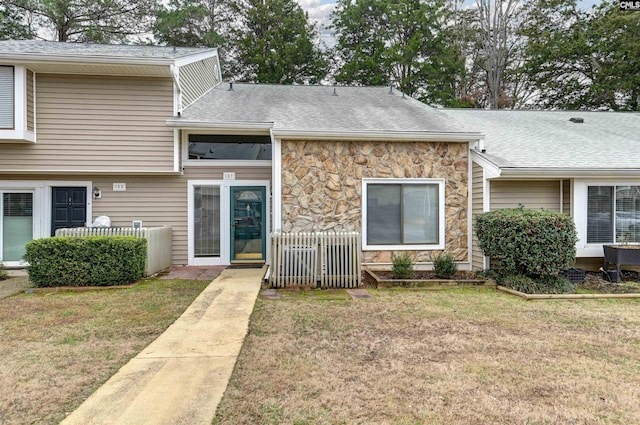 view of exterior entry featuring a lawn