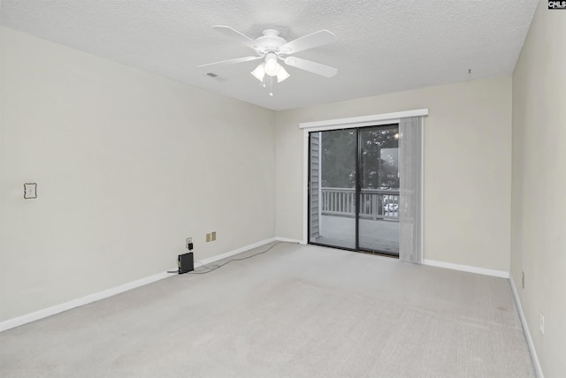 carpeted spare room featuring ceiling fan and a textured ceiling