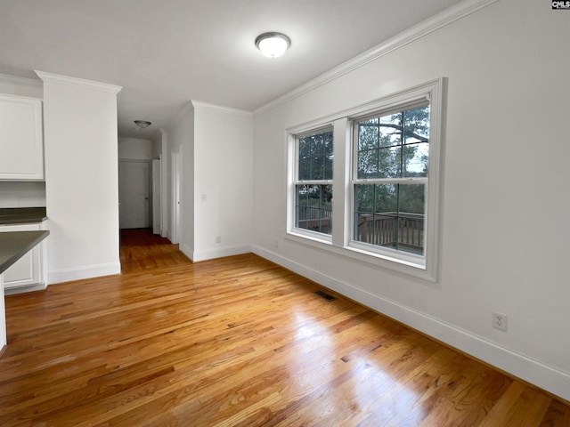 interior space with light hardwood / wood-style floors and crown molding