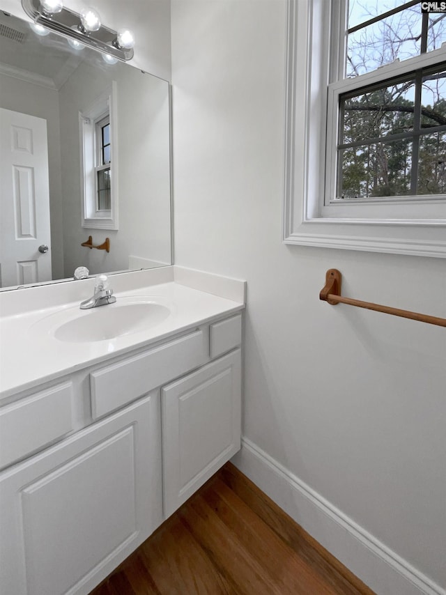 bathroom with vanity, hardwood / wood-style floors, and crown molding