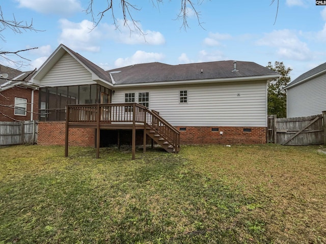 back of property with a lawn, a sunroom, and a wooden deck