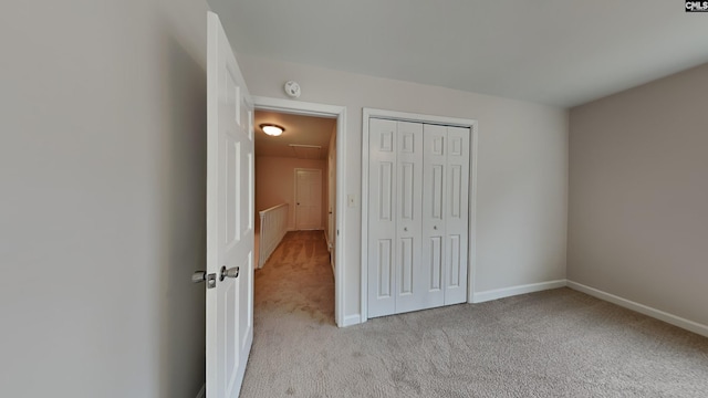 unfurnished bedroom featuring a closet and light colored carpet