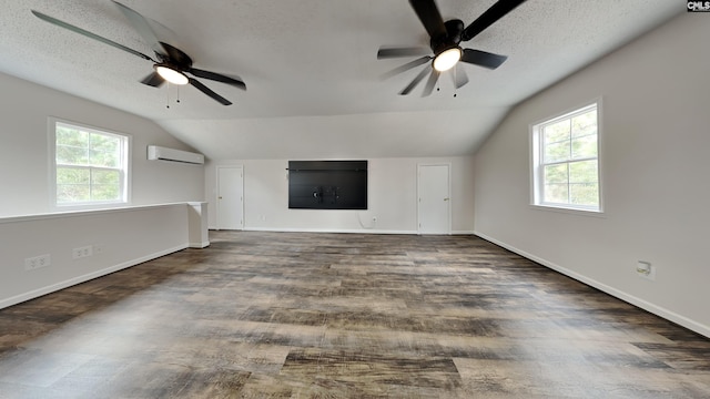 unfurnished living room with ceiling fan, vaulted ceiling, plenty of natural light, and a wall unit AC