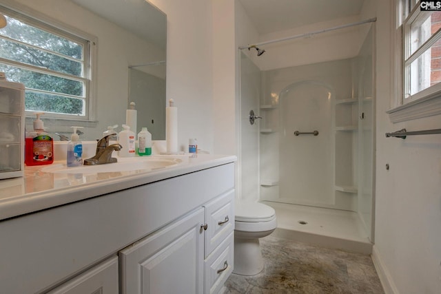 bathroom with vanity, a shower, and toilet