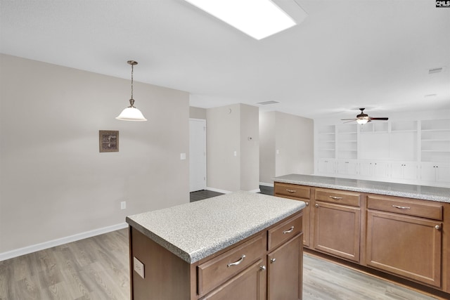 kitchen featuring a kitchen island, ceiling fan, pendant lighting, and light hardwood / wood-style flooring