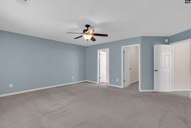 empty room with light carpet, ceiling fan, and a textured ceiling