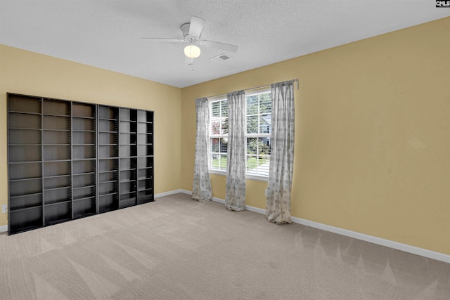 interior space featuring carpet flooring, a textured ceiling, and ceiling fan