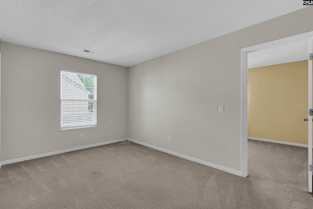 unfurnished room featuring a textured ceiling and light colored carpet