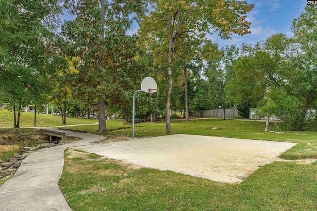 view of sport court with a lawn