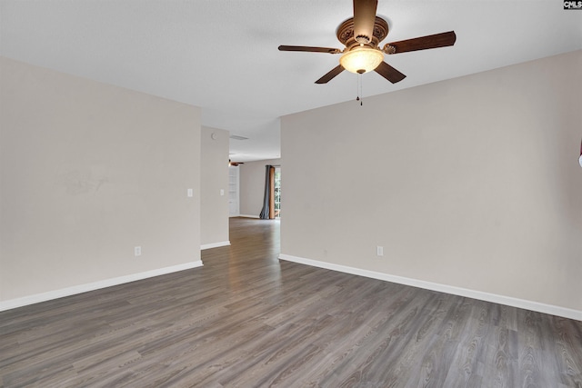 unfurnished room featuring ceiling fan and dark wood-type flooring