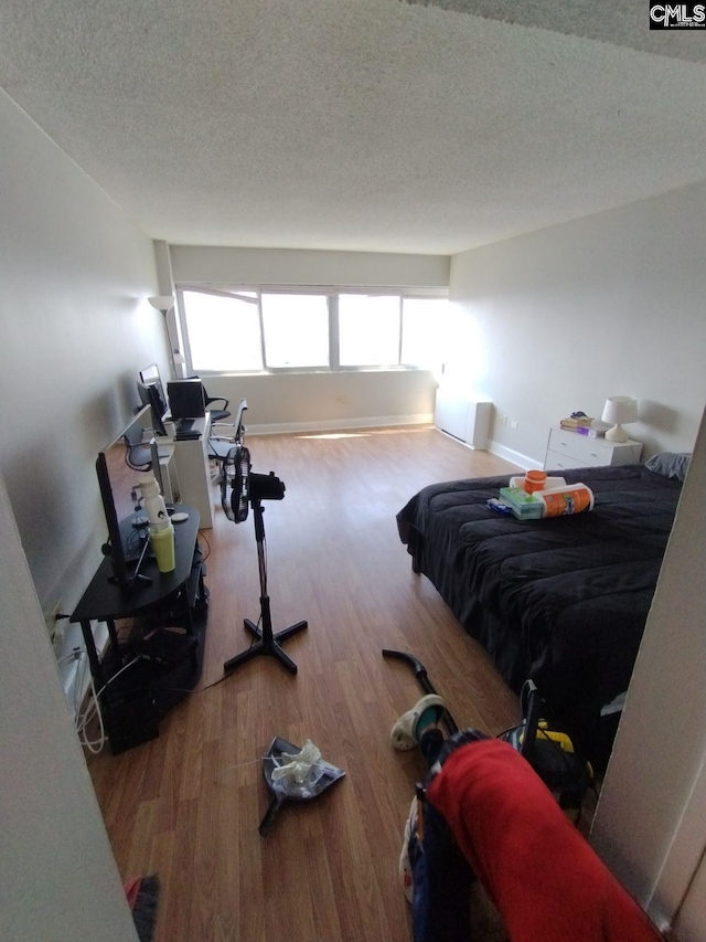 bedroom with a textured ceiling and hardwood / wood-style flooring