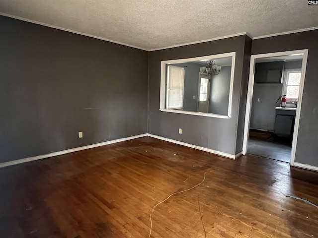 unfurnished room featuring hardwood / wood-style floors, a textured ceiling, a chandelier, and crown molding