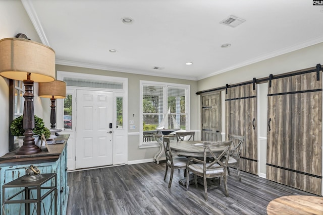 dining area with ornamental molding, a barn door, and dark hardwood / wood-style floors