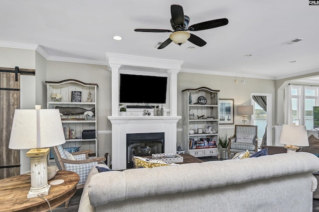 living room with ceiling fan, hardwood / wood-style floors, ornamental molding, and a fireplace