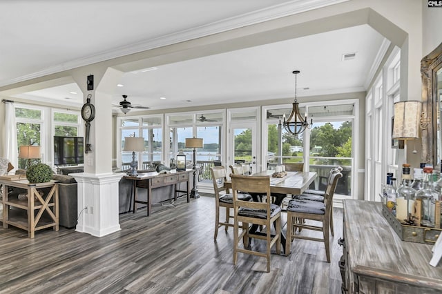 dining area featuring ceiling fan with notable chandelier, dark wood-type flooring, and ornamental molding