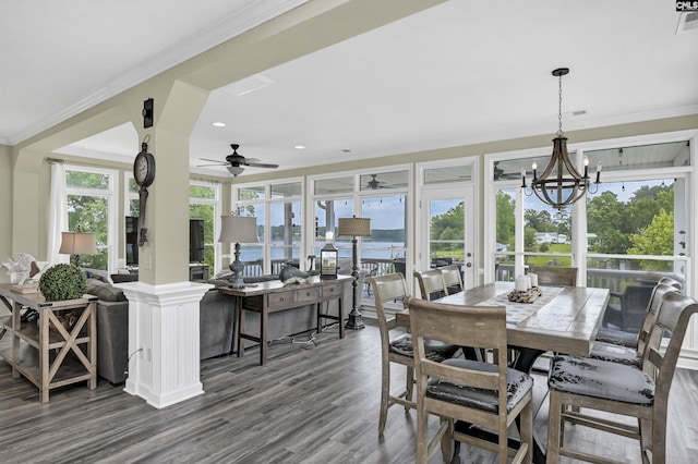 dining area with ceiling fan with notable chandelier, hardwood / wood-style flooring, crown molding, and a healthy amount of sunlight