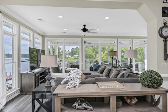 living room featuring wood-type flooring, ceiling fan, and ornamental molding