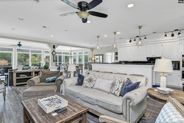 living room featuring ceiling fan, a healthy amount of sunlight, and crown molding