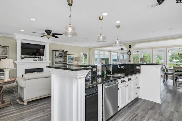 kitchen with a center island with sink, white cabinetry, and hanging light fixtures