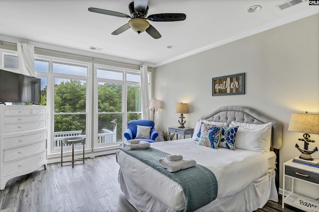 bedroom featuring hardwood / wood-style flooring, ceiling fan, and ornamental molding