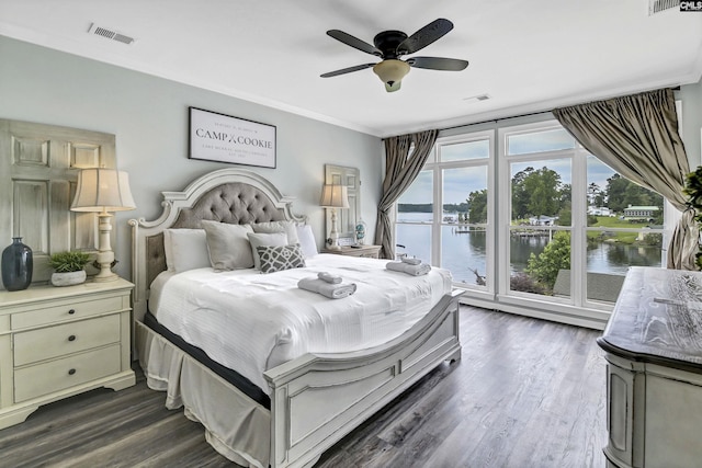 bedroom featuring dark hardwood / wood-style floors, access to exterior, ceiling fan, and a water view