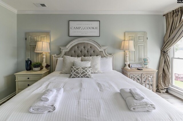 bedroom with hardwood / wood-style floors and ornamental molding