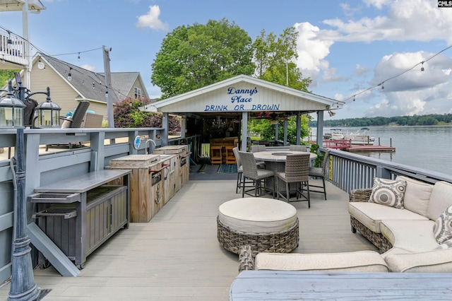 wooden deck with an outdoor bar, outdoor lounge area, and a water view