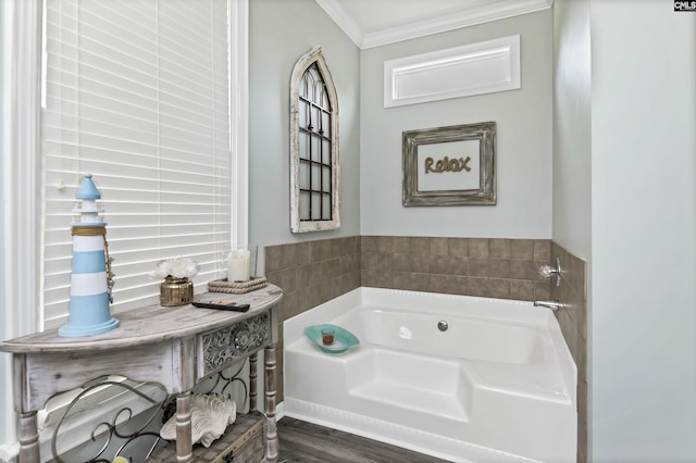 bathroom with ornamental molding, hardwood / wood-style floors, and a tub