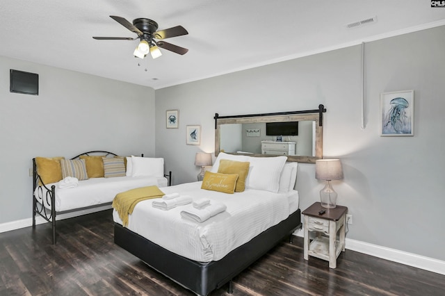 bedroom featuring ornamental molding, ceiling fan, dark hardwood / wood-style floors, and a barn door